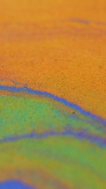 Dikey video. Parlak boya dalgası. Sıvı ışıltılı doku. Bulanık turuncu mor renk metalik parlak kum tanecikleri mürekkep akrilik akışkan akış hareketi soyut sanat arka planı.