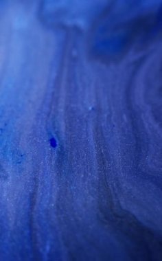 Dikey video. Islak sim sıçraması. Parlak doku. Odaklanmamış mavi renk gradyanı parıldayan partiküller sıvı mürekkep parlatıcısı hareketi karanlık soyut sanat arkaplanı.