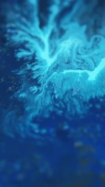 Dikey video. Akrilik boya sıçraması. Köpüklü sıvı. Odaklanmamış mavi renkli parlak parçacıklar mürekkep pigmenti emülsiyonu sıvı akış hareketi soyut sanat arka planı.