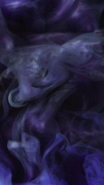 Dikey video. Parlak mürekkep suyu. Gece sisi. Odaklanamayan mavi mor renk parıldayan parçacıklar. Kara siyah soyut sanat arka planında duman bulutu hareketliliği..