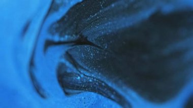 Köpüklü boya karışımı. Parıltı dökülüyor. Odaklanmamış siyah mavi renk parıldayan parçacıklar dokusu akrilik dalga hareketi soyut sanat arkaplanı.