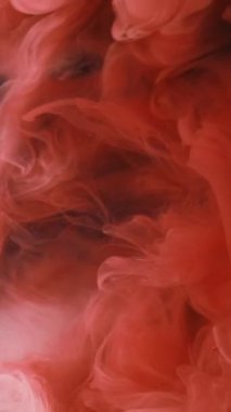 Dikey video. Patlama bulutu. Mürekkep damlası. Odaklanmamış kırmızı renk toz dokusu duman dalgası akışı siyah soyut sanat arka planında hareketi gösterir.