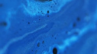 Akrilik köpük. Yumuşak sıvı doku. Odaklanmamış mavi renk ışıldayan parçacıklar emülsiyon karışımı dökülme hareketi soyut sanat arkaplanı.