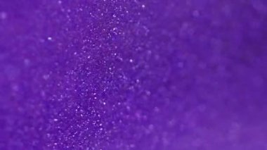 Parlak bir geçmişi var. Bokeh ışığı. Odaklanamayan mor beyaz renkli parlayan tanecikler soyut sanat dokusu..