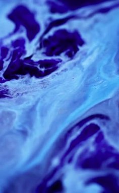 Dikey video. Sıvı sıçraması. Boya akışı. Odaklanamayan soğuk mavi renk parlayan akrilik mürekkep sızıntısı dalgası yaratıcı soyut sanat arka planı.