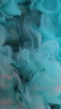 Dikey video. Su damlasını boya. Duman bulutu. Odaklanmamış mavi bronz renkler ışıldayan parçacıklar siyah soyut sanat arka planında sis dalgası hareketi.