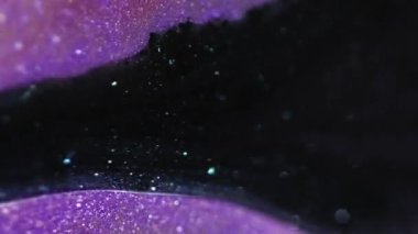 Parlak bir damla. Parıltı damlıyor. Odaklanamayan siyah mor renk parıldayan desen akrilik boya akışı hareketi soyut sanat arkaplanı bokeh ışık.