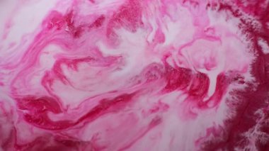 Renkli sıvı. Parıltı akışı. Beyaz pembe kırmızı karışımlı sıvı pigment dokusu girdaplı parlak metal cilası parçacıkları mürekkep soyut arkaplan bulanıklığı.
