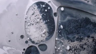 Akrilik kütle. Kabarcık emülsiyonu. Pigment parçacıkları grunge suyunda yüzüyor. Gri siyah mürekkep damlası patlaması karışık bulanık arkaplan.