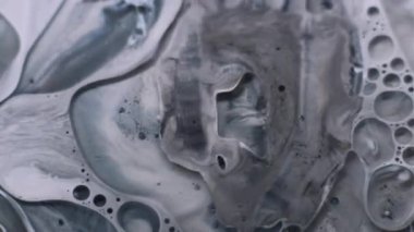 Mürekkep katmanları. Yağ sıvısı. Kirli yüzeyde yüzen gri beyaz siyah pigment. Odaklanmamış grunge harmanı şeffaf nokta soyut arkaplanı.