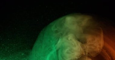 Renkli duman. Mistik akış. Duman mürekkebi patlaması pırıl pırıl parlayan yüzeye yayılan kıvrımlar siyah soyut parlak bulanık su arkaplanı.