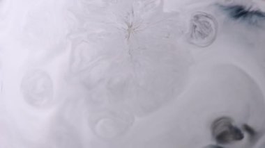 Mürekkep akışı. Sıvı damlası. Gri beyaz mermer akışı soyut arka plan sıvı yüzeyinde ortaya çıkar. Siyah pigment lekesi çözülmüş serpinti..