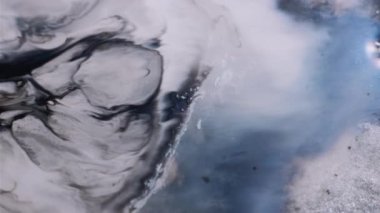 Sanat sıvısı. Mürekkep döküldü. Odaklanmamış beyaz siyah pigment parıldayan toz parçacıkları emülsiyon karışımı. Mermer girdap akışı soyut arkaplan.