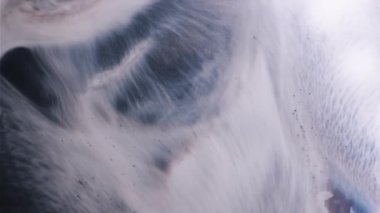 Mermer akışı. Enamel karışımı. Pürüzsüz grunge dalgası gri beyaz boya yüzeyi döker. Siyah akryl pigmenti sıvı parçacıkları soyut arkaplan yaydı.