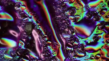 Folyo sıvısı. Islak yüzey. Yanardöner camların üzerindeki renkli akarsular. Suyun spektrum ışığı kaotik işaret fişeği parlayan nem oyunuyla yansımaları değiştiriyor.