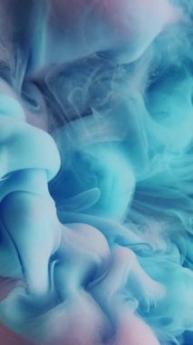 Dikey video. Boya damlası suyu. Renkli duman bulutu. Odaklanmamış pembe akrilik mürekkep karışımı sıçrama akışı, hareket buharı dokusunun soyut sanat arkaplanı olduğunu gösteriyor..