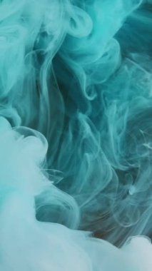 Dikey video. Çarpık duman. Parıldayan sıvı. Ruhsal aura. Mavi gök mavisi soyut buharı altın rengi parlak arka plandaki gizemli sislerin üzerine parlayan sihirli buhar..