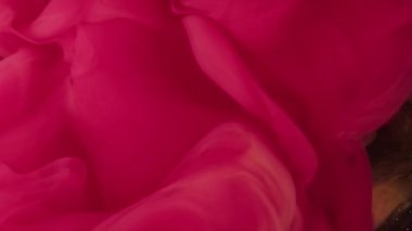 Renk buharı. Boya bulutu. Magenta pembe mürekkep su kıvrımlı koyu siyah simli parçacıklar üzerinde soyut sanat arkaplanı.