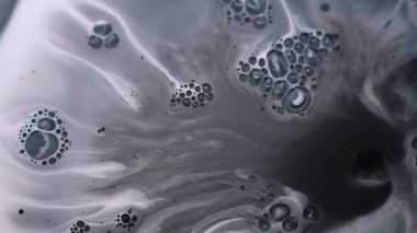 Mürekkep değişimi. Sanat patlaması. Düz olmayan beyaz yüzeyde gri baloncuk lekesi patladı. Grunge akış parçacıkları su soyut arkaplan.