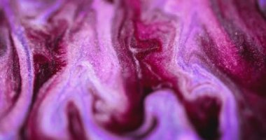 Işıldayan sıvı dökülmesi. Islak sim akışı. Odaklanmamış morumsu pembe renkli parlak parçacıklar akrilik mürekkep dalgası, soyut sanat arkaplanı ve bokeh ışık.