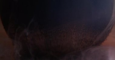 Grunge akışı. Sanat küresi. Yuvarlak büfeden dökülen siyah toz sıvı boya. Mistik koyu kül pigmenti soyut turuncu bulanık arkaplan.