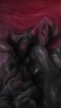 Dikey video. Parlak mürekkep suyu. Duman bulutu. Odaklanmamış pembe renkli parlak parçacıklar patlama dokusu buhar akışı hareket soyut sanat arkaplanı ortaya çıkarıyor.