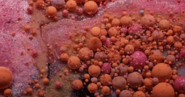 Mistik akış. Acryl kabarcığı. Turuncu pembe kıvrımlı köpüklü yağ emülsiyon dokusu. Suyun soyut duman arka planında renkli mürekkep damlaları.