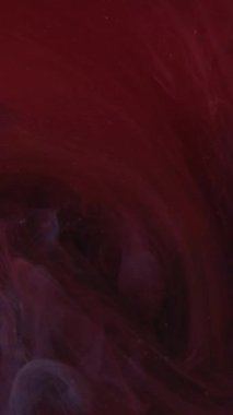 Dikey video. Renkli duman girdabı. Mürekkep suyu karışımı. Odaklanmamış kırmızı mavi toz parçacıkları yüzen buhar bulutu girdabı hareket soyut sanat arkaplanı ortaya çıkarıyor.