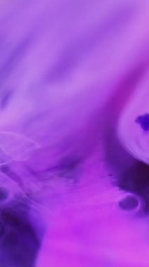 Dikey video. Renk sisi. Su karışımı boya. Odaklanmamış pembe şeffaf yağ kabarcıkları yüzen sıvı akış hareketi soyut sanat arka planı.