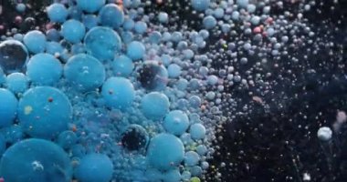 Akrilik baloncuk. Fizzy sıvısı. Mavi, siyah, köpüklü, mürekkepli su akışı. Patlayan yağ parçacıkları renk damlaları soyut arkaplanı bulanıklaştırır.