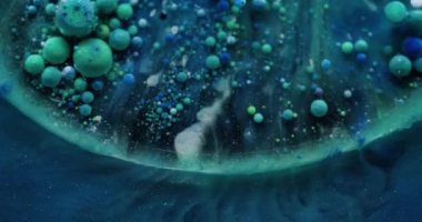 Yağlı boya. Renkli sıvı. Sanat akışı katmanları küçük parçacıkları boyar. Mistik parıldayan mavi yeşil sıvı soyut arkaplan.