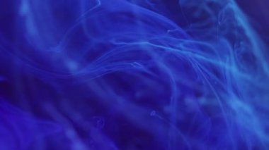 Sis büyüsü. Yüzen darbe. Parlak mavi sıçrama mürekkebi parlayan buhar bulutu dumanı soyut sanat arka planında hareket ediyor..