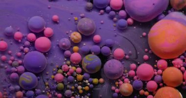 Baloncuk döküldü. Boya karışımı. Yağlı pembe turuncu damlalar suda eriyor. Sanat pigmenti parlatıcı tozu soyut arkaplan sıçratır.