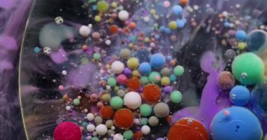 Baloncuk döküldü. Mürekkep akışı. Yağlı boya damlaları suda eriyor. Renkli akrilik pigment köpük yüzen soyut sanat arkaplanı.