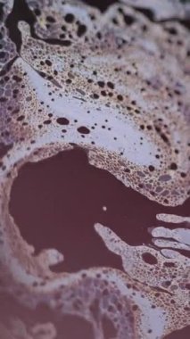 Dikey video. Asit köpüğü. Kimyasal sıvı. Odaklanmamış mavi renk baloncukları dokusu, emülsiyon, koyu siyah soyut sanat arka planında akış dalgası hareketi..