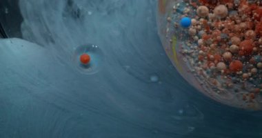 Mistik akış. Mermer baloncuklar. Mavi gri akarsu, dönen yağ çemberi. Su soyut duman arka planında yuvarlak turuncu bej mürekkep damlaları.