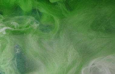 Bulut dumanı. Mürekkep suyu. Odaklanmamış yeşil beyaz renkler parıldıyor. Parlayan soyut sanat ışığı arka planında boya deseni sisi yüzüyor..