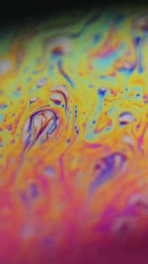 Dikey video. Mürekkep rengi gökkuşağı. Psikedelik spektrum. Koyu siyah soyut sanat arka planında çözünmüş sarı mavi renk eğrisi yağ kimyasal sıvı akış hareketi.