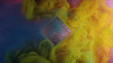 Renkleri karıştırıyorum. Boya dökülmüş. Parlak mavi duman dumanı simli küp mürekkep dokusu mor parıldayan sanat arka planında yüzüyor..