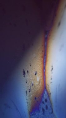 Dikey video. Bulanık köpük karışımı. Köpük sıvısı. Odaklanmamış mavi turuncu renkli köpüklü desen, koyu siyah ışık parlaması üzerinde sıvı dalgası, soyut sanat arkaplanı..