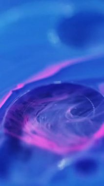 Dikey video. Bulanık kabarcıklar. Yağ emülsiyonu. Odaklanmamış mavi renk damlacıkları yüzen akrilik doku boya su harmanı girdap hareketi soyut sanat arka planı.