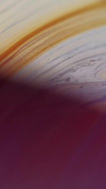 Dikey video. Yağ lekesi. Görünmez mürekkep karışımı. Odaklanmamış mor renkli akrilik emülsiyon mermer kıvrımlar koyu soyut sanat arka planında dalgalanır.