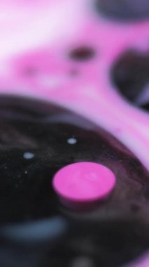 Dikey video. Mürekkep kabarcıkları. Köpüklü sıvı. Odaklanmamış siyah beyaz renkli yuvarlak damlacıklar yüzen akrilik doku sıvı hareketli soyut sanat arka planı.