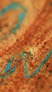 Dikey video. Altın döküldü. Parıltı dalgası. Odaklanmamış turuncu bronz mavi renk parıldayan parçacıklar desen boya akış hareketi soyut sanat arkaplanı bokeh ışık.