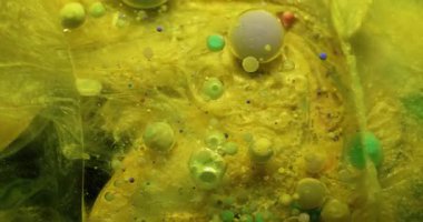 Boya akışı. Kabarcık emülsiyonu. Yüzen renkli damlaları karıştıran mistik sarı mermer. Dalgalar ışıl ışıl soyut arkaplan.