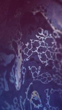 Dikey video. Mürekkep köpüğü. Köpüklü sıvı akışı. Odaklanmamış mavi sarı renk yağ dokusu koyu soyut sanat arka planında sıvı dalga hareketi.