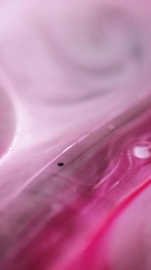 Dikey video. Yağ serumu. Mürekkep suyu karışımı. Odaklanmamış pembe şeffaf yuvarlak damlacıklar yüzen jel dokusu sıvı hareket soyut sanat arkaplanı.