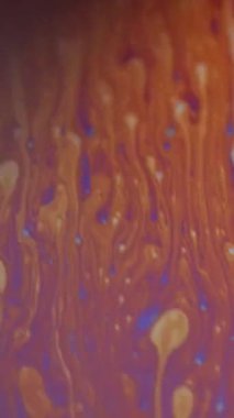 Dikey video. Odaklanmış asit sıvısı. Mürekkep karışımı. Turuncu mavi renk kimyasal baloncuk deseni sıvı boya akışı dalga hareketi soyut sanat arkaplanı.