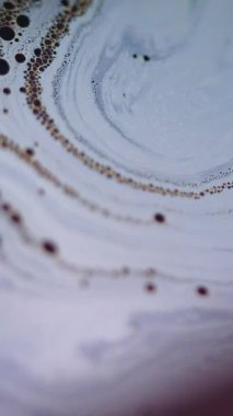 Dikey video. Sabun köpüğü. Kabarcık emülsiyonu. Odaklanmamış mavi turuncu yağ dokusu koyu siyah ışık parlaması üzerinde sıvı akış hareketi soyut sanat arkaplanı.