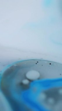 Dikey video. Bulanık kabarcıklar. Yağ emülsiyonu. Odaklanmamış beyaz renk damlacıkları yüzen akrilik doku boyası su karışımı hareketli soyut sanat arkaplanı.